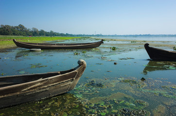 Wooden fishing boats on shore at Taung Tha Man Lake at Amarapura, Mandalay, Myanmar