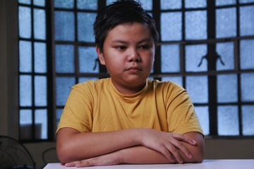 Young Asian boy with blank facial expression