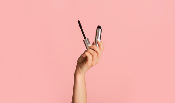 Beauty And Makeup. Young Girl Holding Mascara On Pink Background, Close Up