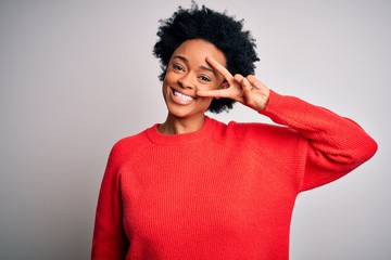 Young beautiful African American afro woman with curly hair wearing red casual sweater Doing peace...