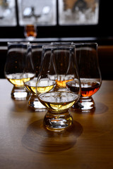 Flight of Scottish whisky, tasting glasses with variety of single malts or blended whiskey spirits on distillery tour in Scotland