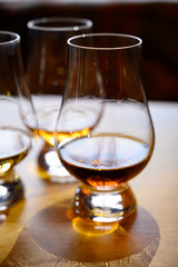 Flight of Scottish whisky, tasting glasses with variety of single malts or blended whiskey spirits on distillery tour in Scotland