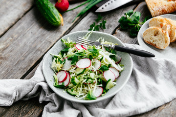 Salad with young cabbage, radish and cucumbers. Vegetarian salad