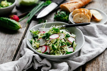 Salad with young cabbage, radish and cucumbers. Vegetarian salad