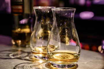 Flight of Scottish whisky, tasting glasses with variety of single malts or blended whiskey spirits on distillery tour in pub in Scotland