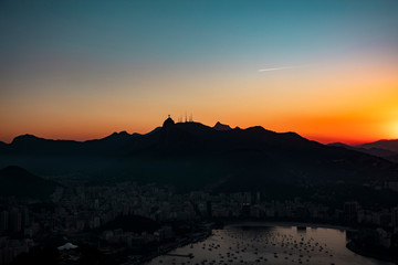 Panoramic aerial view of Guanabara Bay, Christ the Redeemer statue and Sugarloaf Mountain at sunset, Rio de Janeiro, Brazil.