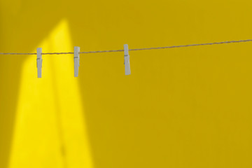 wooden white clothespins hang on a rope
