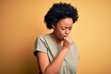 Fototapeta na wymiar Young beautiful African American afro woman with curly hair wearing casual t-shirt feeling unwell and coughing as symptom for cold or bronchitis. Health care concept.