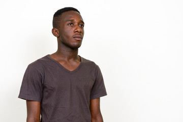 Portrait of young African man thinking and looking up