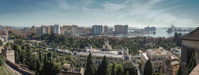Malaga Spain wide panorama landscape cityscape and view of the port, the sea, the bullring and the town skyline on a sunny day with clouds in the sky from the Alcazaba Fortress.