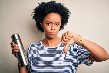 Young African American afro tourist woman with curly hair holding thermo with water with angry face, negative sign showing dislike with thumbs down, rejection concept