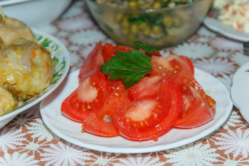  plate with slices of tomato on the background of several dishes 