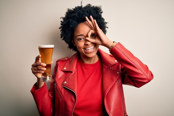 Young African American afro woman with curly hair drinking glass of beer with alcohol with happy...