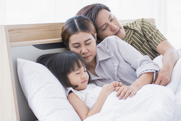 Asian family is sleeping on the bed