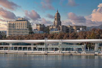 Malaga Cathedral and the Port of Malaga Promenade on a cloudy day.