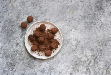 Chocolate truffle with cocoa powder on a concrete background. View from above.