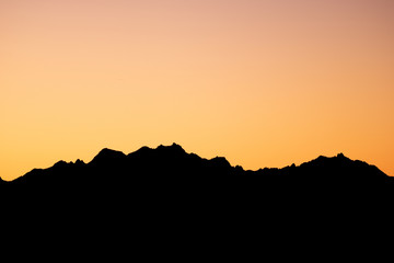 Orange Sun Setting Behind the Mountains