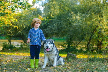 Little kids walking together with their pet dog outdoors. Love kids concept. Little Boy playing with his dog outdoors enjoying together. Childhood concept.