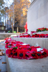 Red poppy wreaths laid around a war memorial for remembrance day