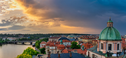 Fototapeta premium Prague roof tops panorama with The Church of Saint Francis of Assisi in front.