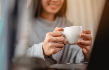 Woman holding a coffee cup work from home wait epidemic situation to improve soon at home. Coronavirus, covid-19, Work from home (WFH), Social distancing, Quarantine, Prevent infection concept.