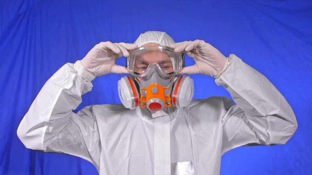 Scientist virologist in respirator. Slow motion. Man close up look, wearing protective medical mask. Concept health safety N1H1 virus protection coronavirus epidemic 2019 nCoV. Chroma key blue film.