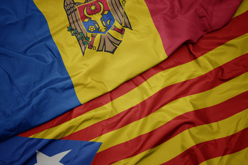 waving colorful flag of catalonia and national flag of moldova.