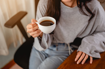 Woman holding a coffee cup work from home wait epidemic situation to improve soon at home. Coronavirus, covid-19, Work from home (WFH), Social distancing, Quarantine, Prevent infection concept.