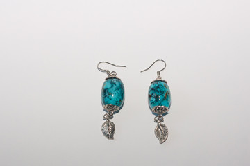 Turquoise earrings on white background. Female accessories, decorative ornaments and jewelry. Fashion and style concept.