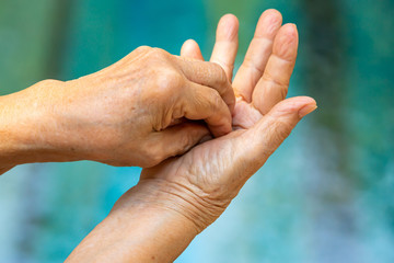 Senior woman's hands washing her hands in step 4 on bokeh blue pool  background, Close up & Macro shot, Selective focus, Prevention from covid19, Bacteria, healthcare concept, 7 step wash hand