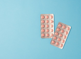 round pink pills in blister packs on a blue background