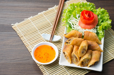 Spring rolls. on white dish in the kitchen / wood and bamboo background /Selective focus image
