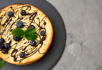 baked curd casserole on a black plate, top view, tasty and healthy dessert