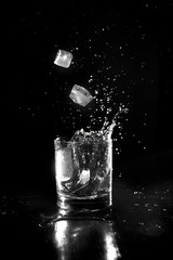 Water on glass with splash on black background.