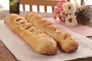 Fresh french baguettes made from white flour on wooden table.