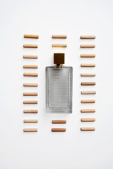 Glass perfume bottle in wooden sticks pattern frame isolated on white background from a high angle view
