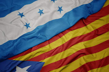 waving colorful flag of catalonia and national flag of honduras.