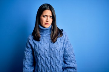 Young brunette woman with blue eyes wearing casual turtleneck sweater skeptic and nervous, frowning upset because of problem. Negative person.