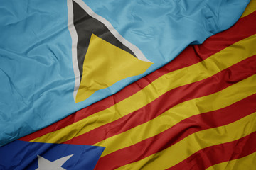 waving colorful flag of catalonia and national flag of saint lucia.