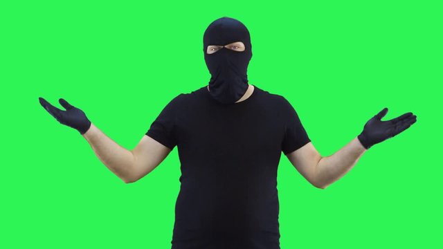 A man in a balaclava offers to make a choice with both hands,green screen background