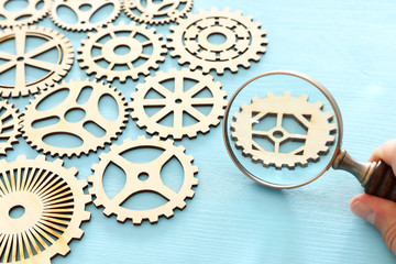 hand placing a cogwheel in set of gears mechanism