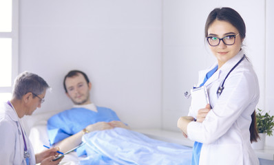 Doctor checking heart beat of patient in bed with stethoscope