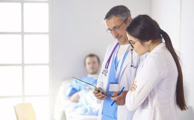 Doctor checking heart beat of patient in bed with stethoscope