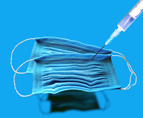 blue medical masks and syringe. Coronavirus concept