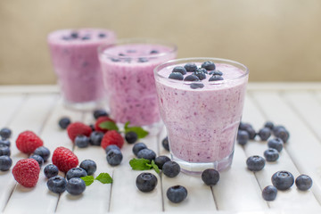 Healthy breakfast of smoothie, dessert, yogurt or milkshake with fresh berries on whtite wooden table 