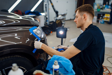 Worker prepares car to applying of protection film