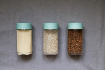 cereals on a linen gray tablecloth, buckwheat, semolina, wheat