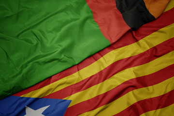 waving colorful flag of catalonia and national flag of zambia.