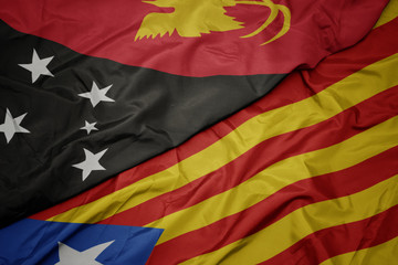 waving colorful flag of catalonia and national flag of Papua New Guinea .