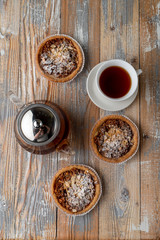Homemade tartlet with nuts and honey with a cup of black tea on rustic wooden table